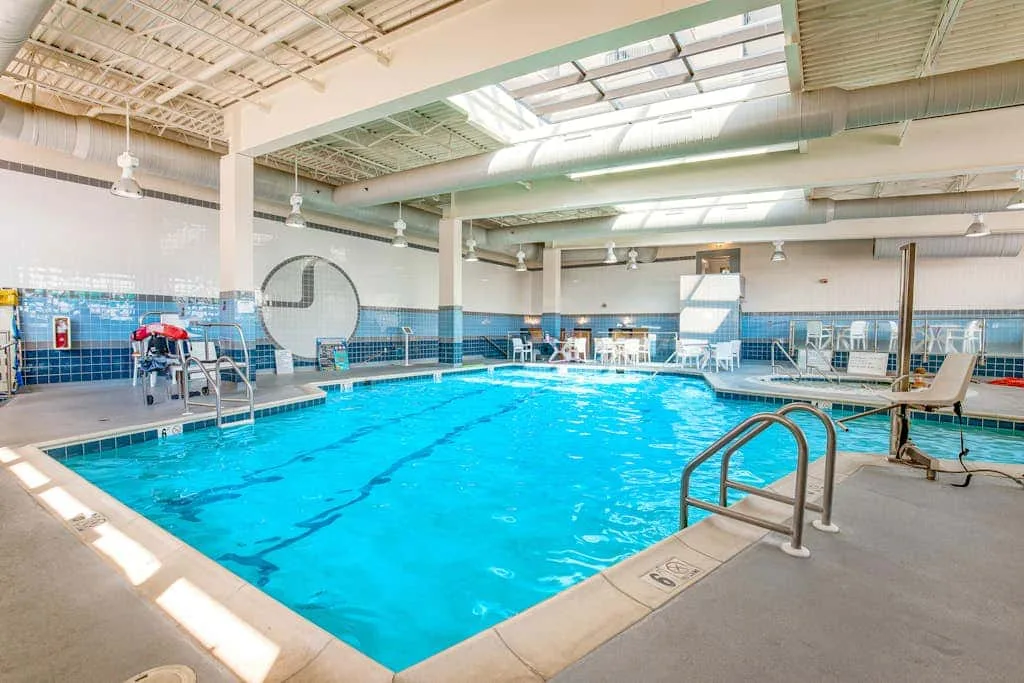 An indoor swimming pool with lane markings and a metal handrail.