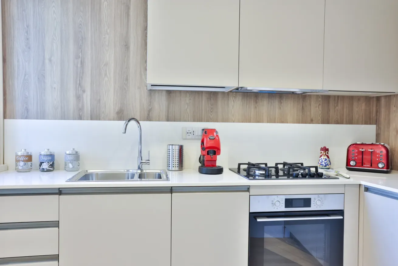 A modern kitchen with a sink, gas cooktop, and built-in oven.