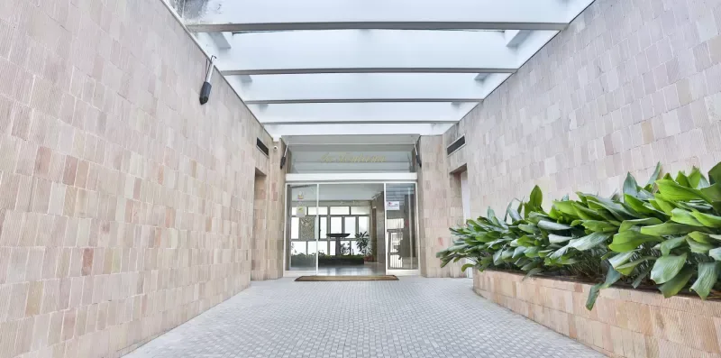 A covered entrance passage leads to glass doors, with a long planter along one side.
