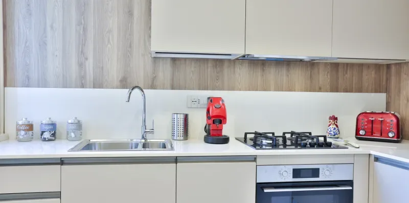 A modern kitchen with a sink, stovetop, and countertop appliances.