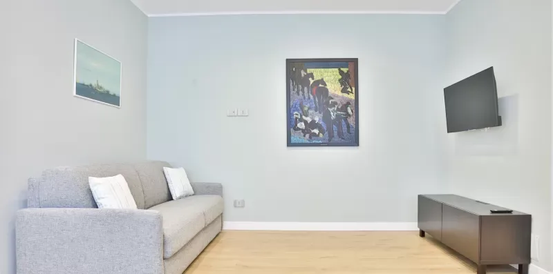 A living room with seating, framed artwork, and a television.