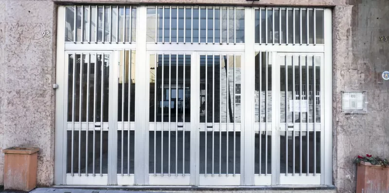 A barred metal entrance fills the front of a building.