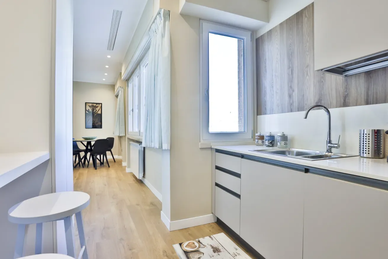 A bright kitchen with a dining area visible in the adjoining space.