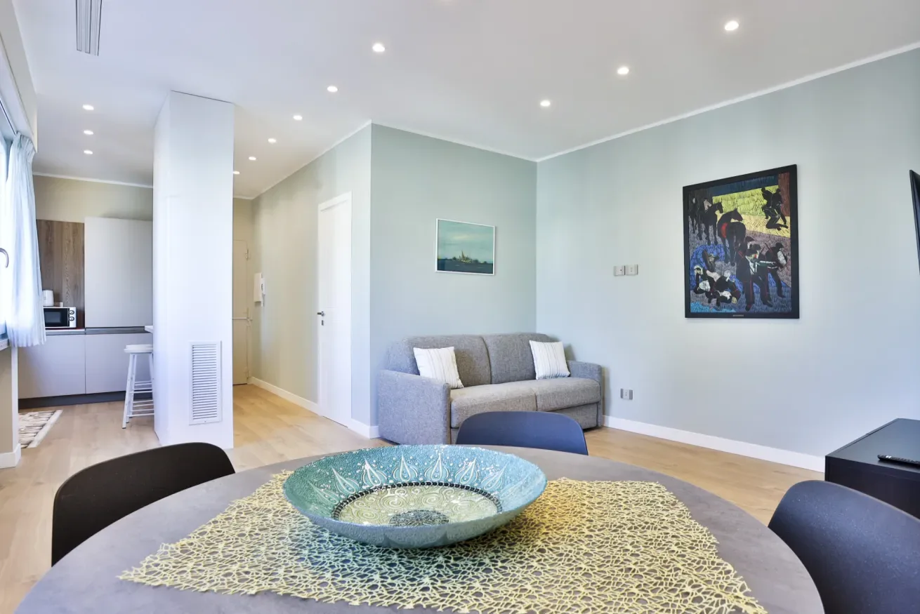 Living room with a gray sofa and a round table in the foreground.