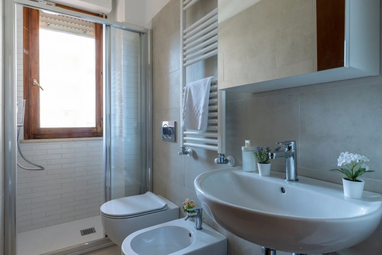 A bright bathroom with a bathtub, sink, and window.