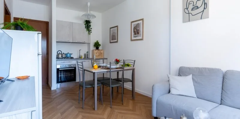 A bright living area with a dining table beside a compact kitchen.