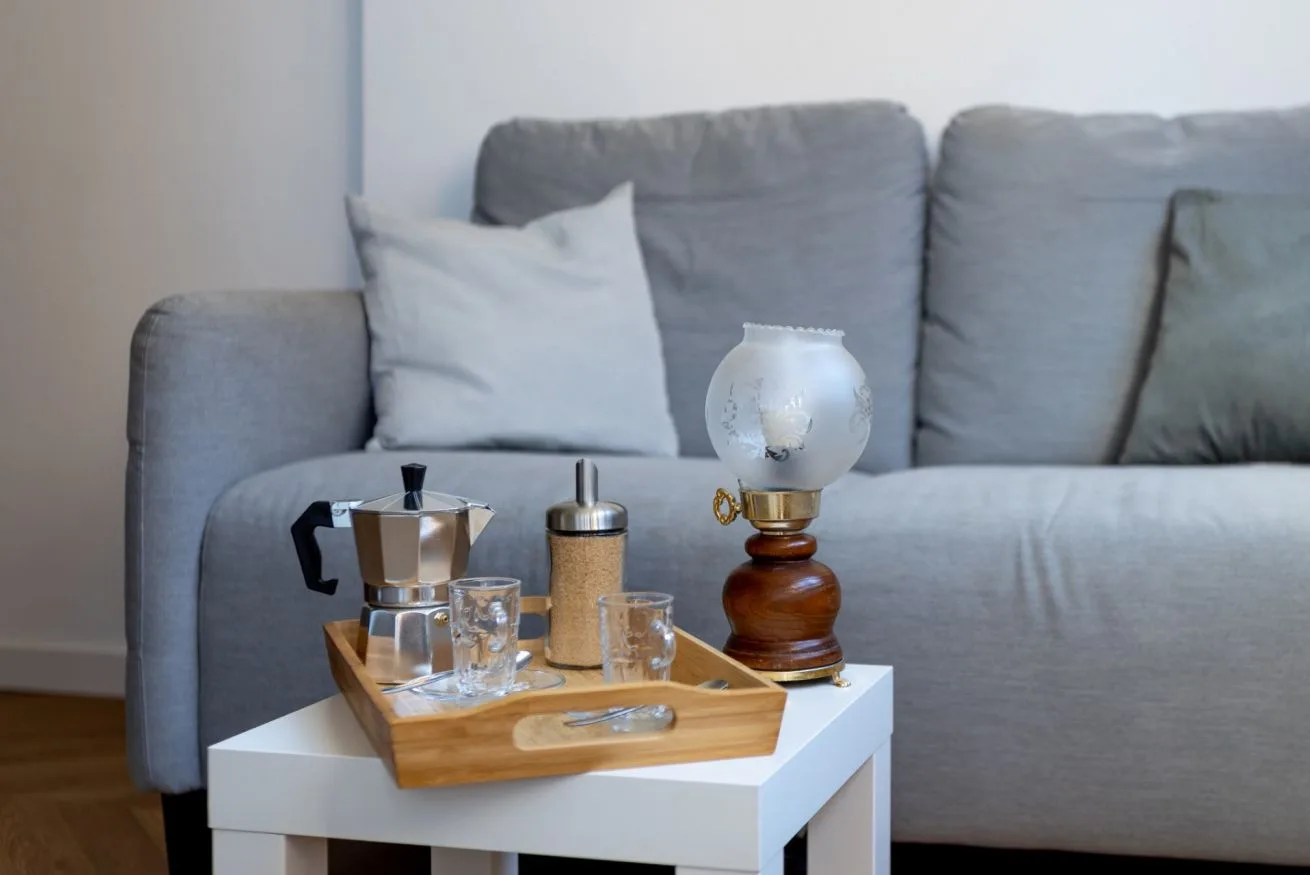 A living room seating area with a gray sofa and a white coffee table.