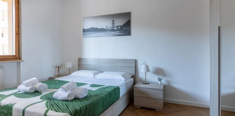 A bedroom with a neatly made bed and matching bedside tables.