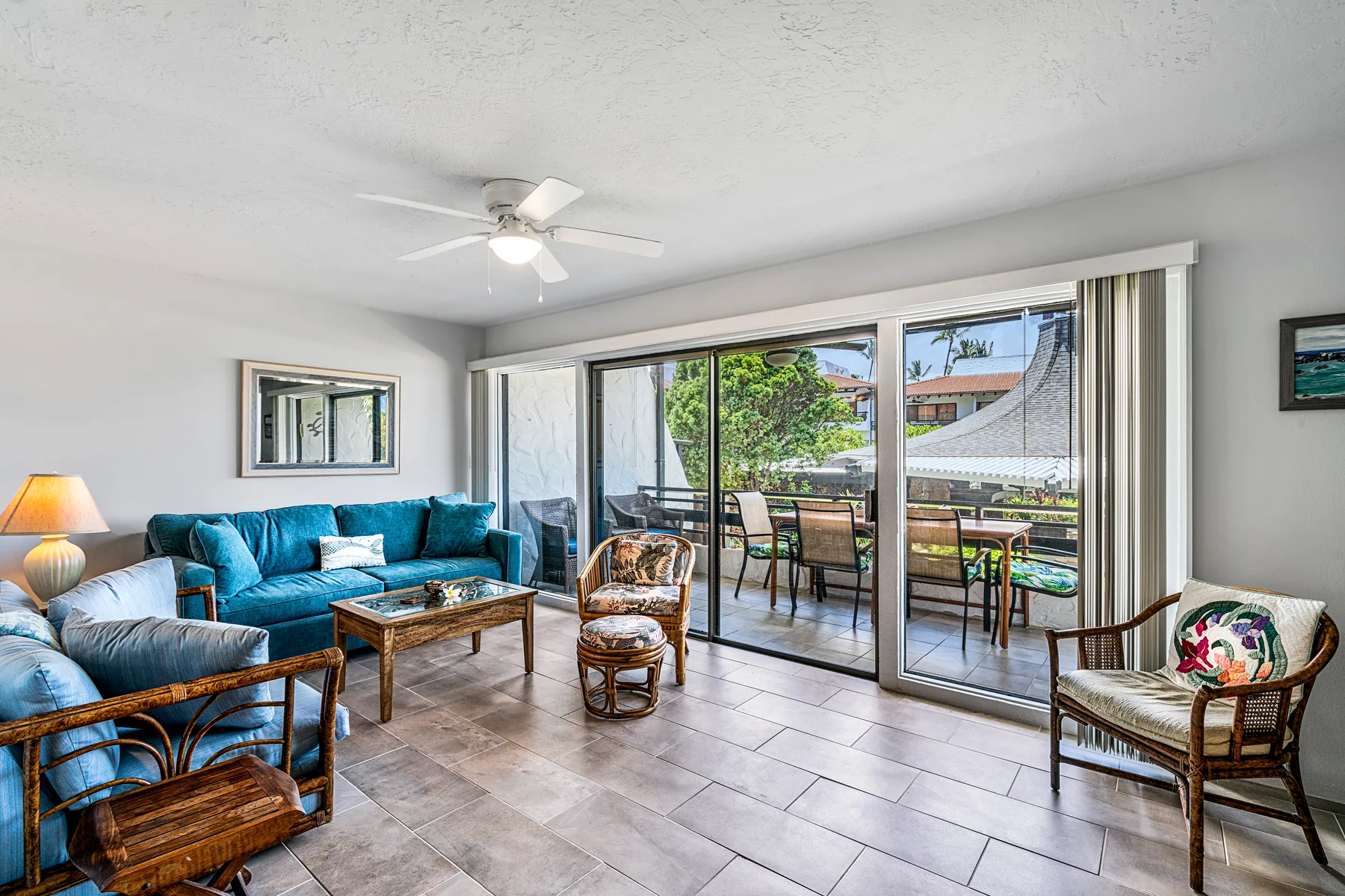 A living room opens onto a patio through wide sliding glass doors.