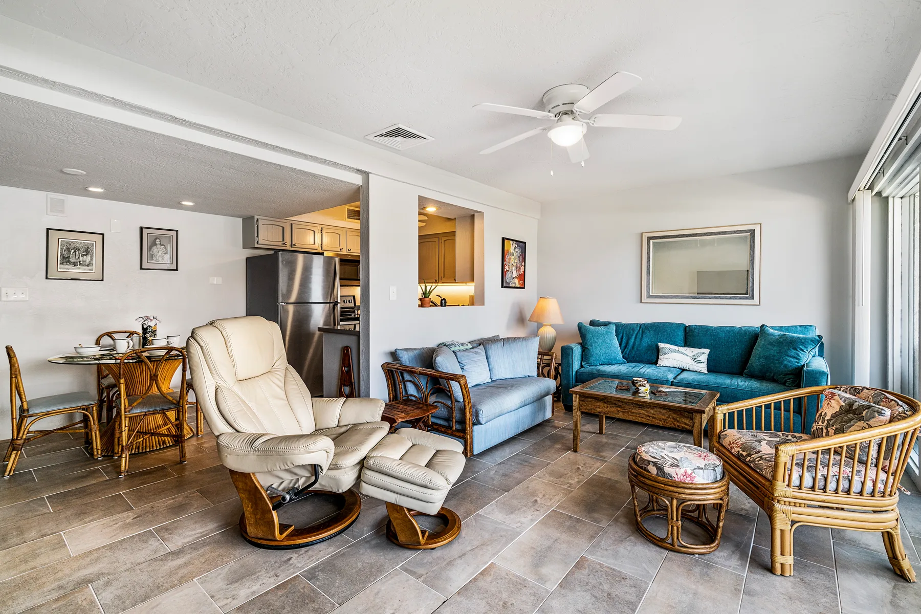 A living room with seating, a coffee table, and a dining nook.