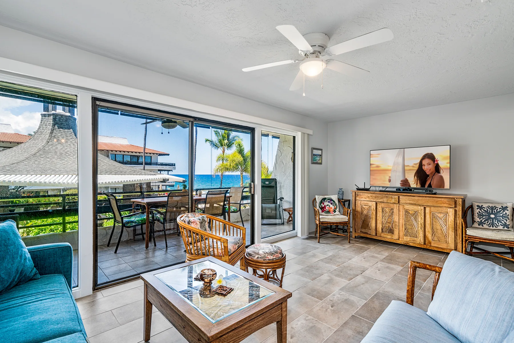 A living room opens onto a furnished balcony through wide glass doors.