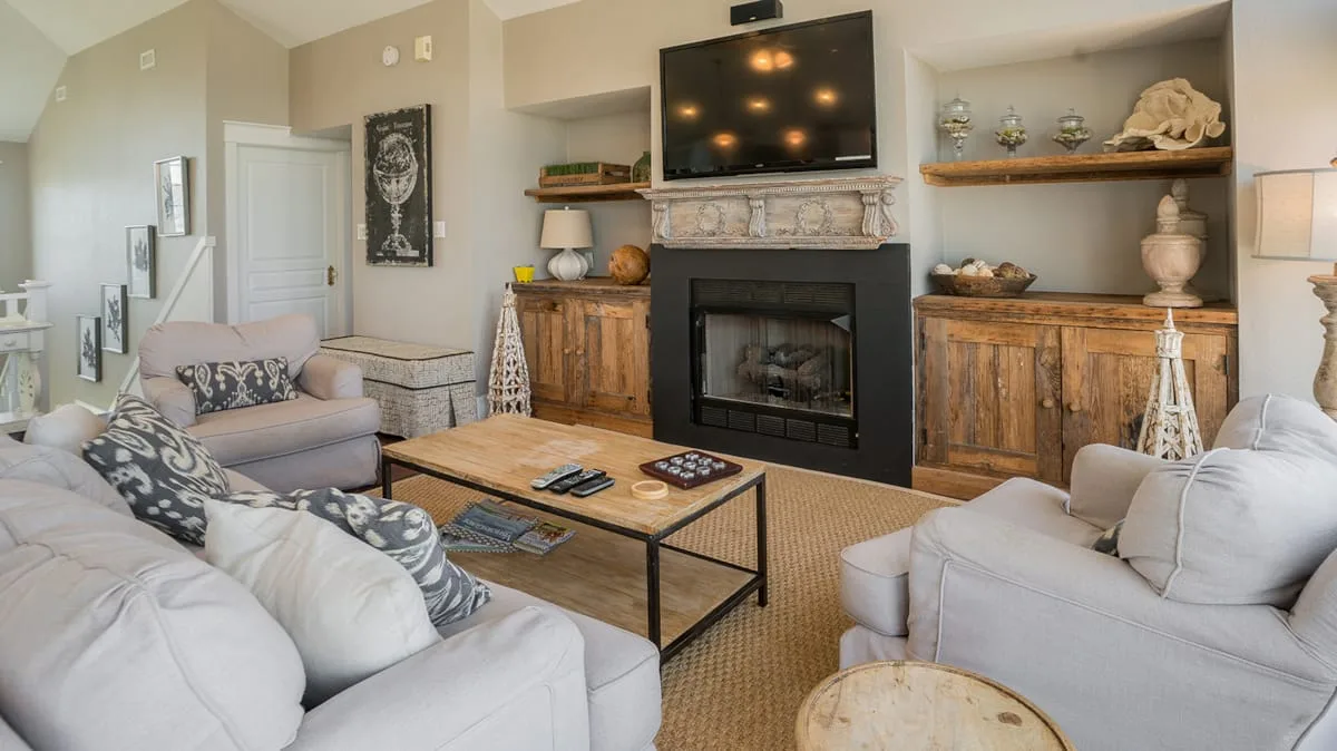 A living room with seating arranged around a coffee table and fireplace.