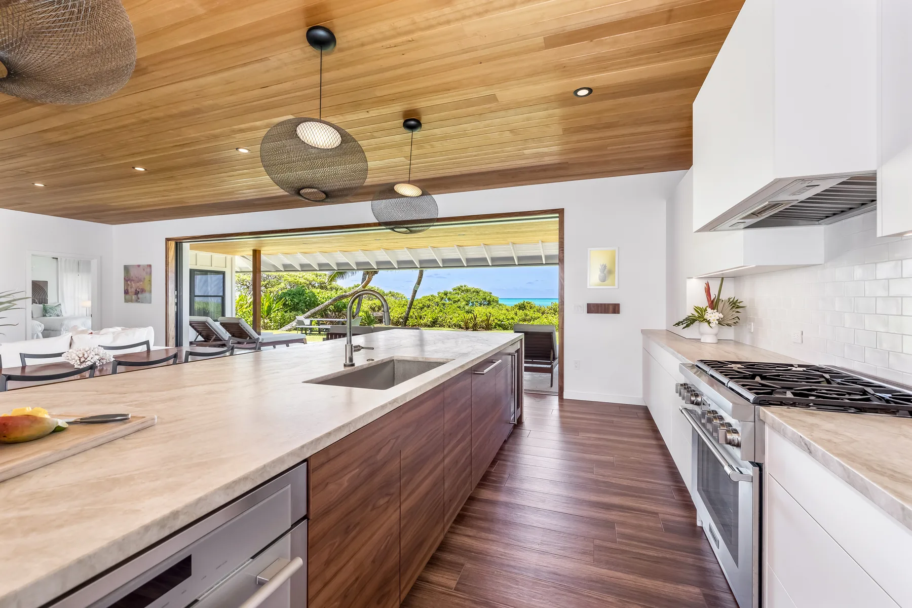 A bright open kitchen and living area with a long island and ocean views.
