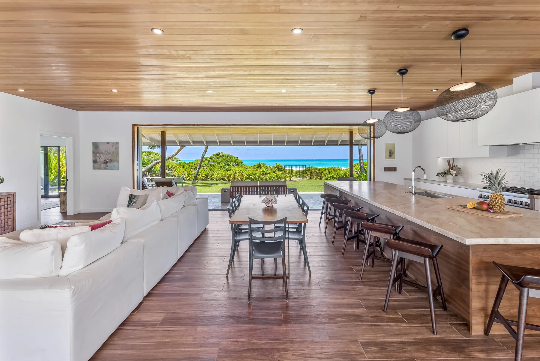 An open-plan living, dining, and kitchen area opens onto a view of the water.