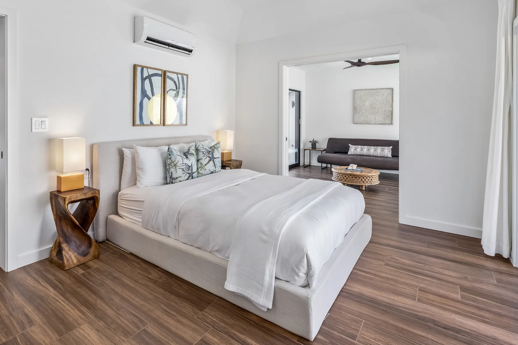 A bedroom with a made bed and an adjoining sitting area.