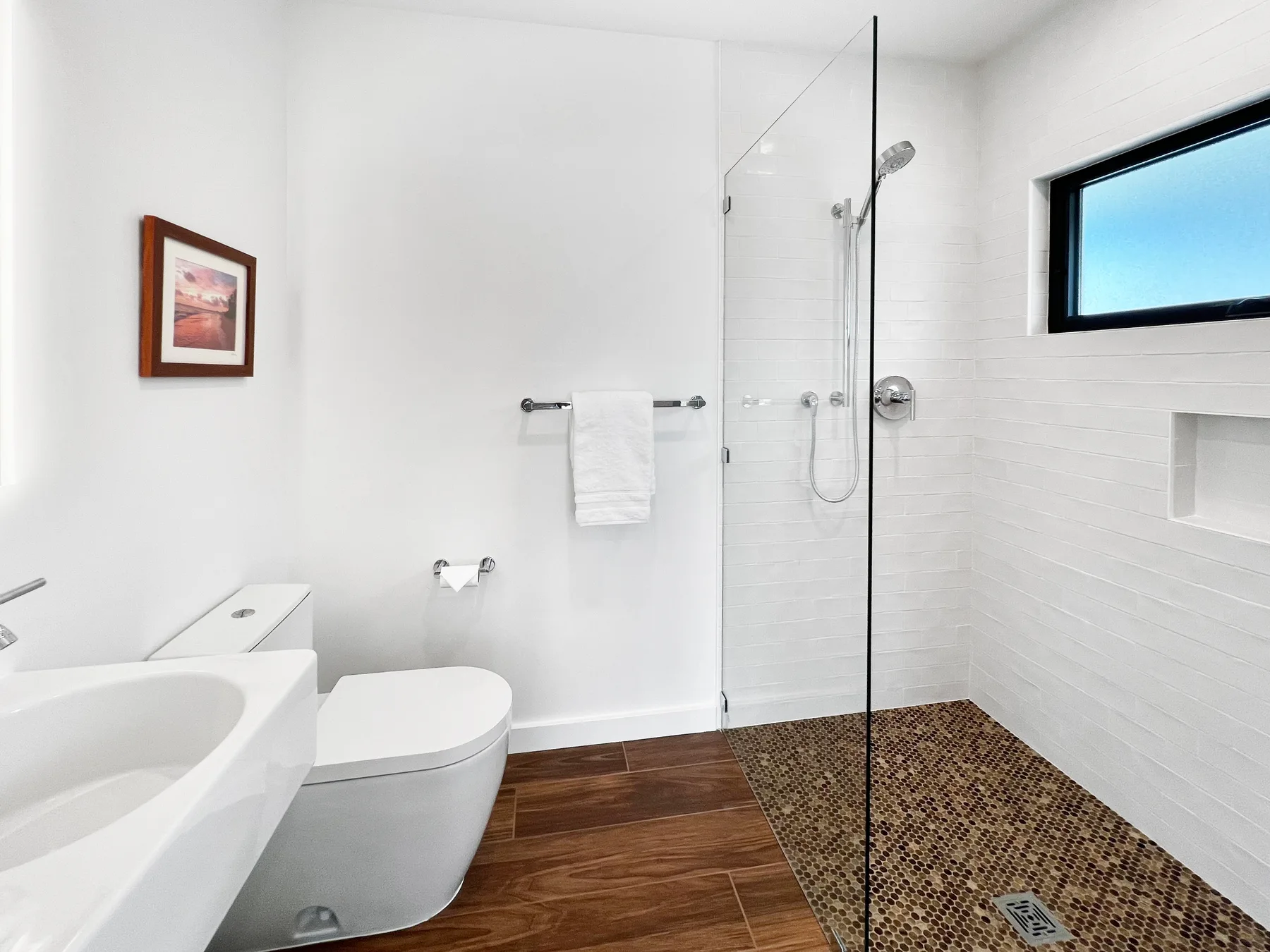 A bright bathroom with a bathtub, toilet, and walk-in shower.