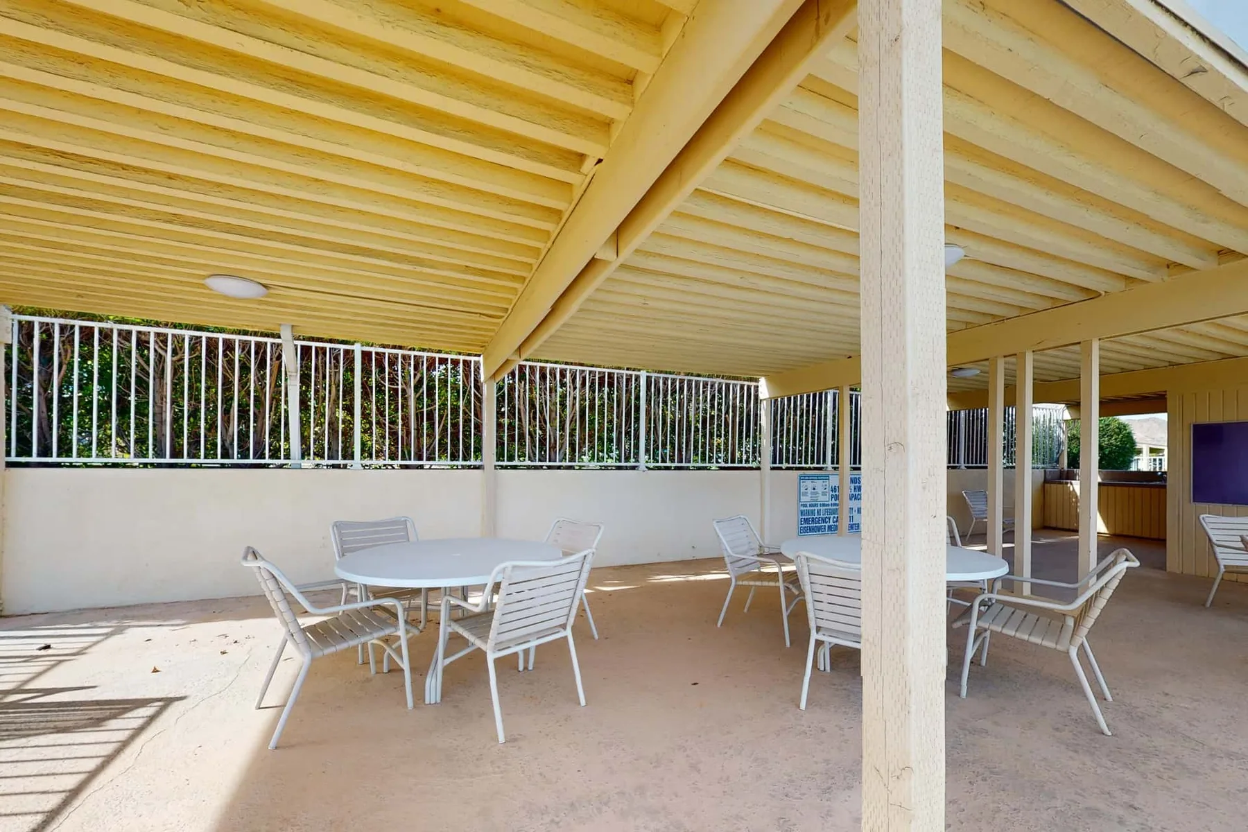 A covered outdoor patio with tables and seating.