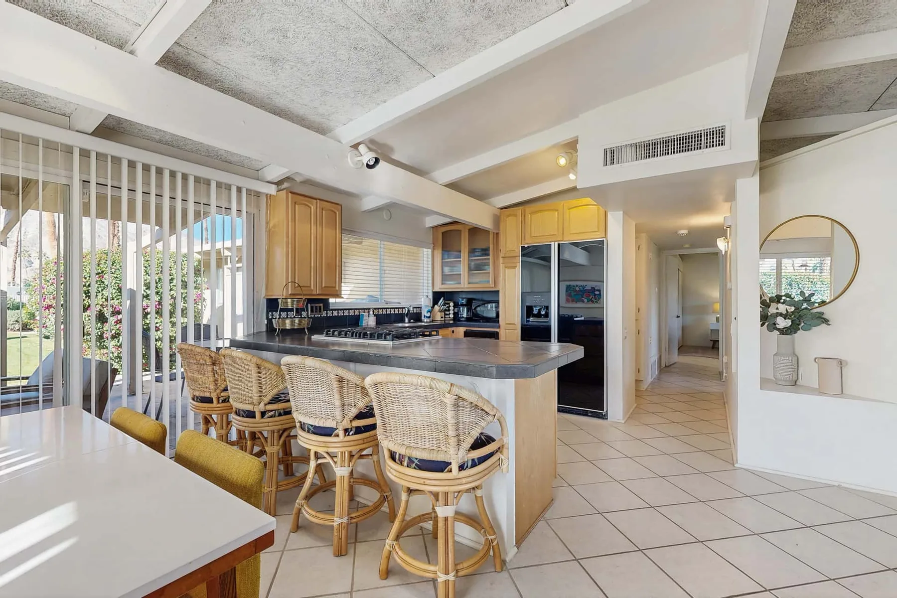An open kitchen and dining area with a central counter and woven seating.
