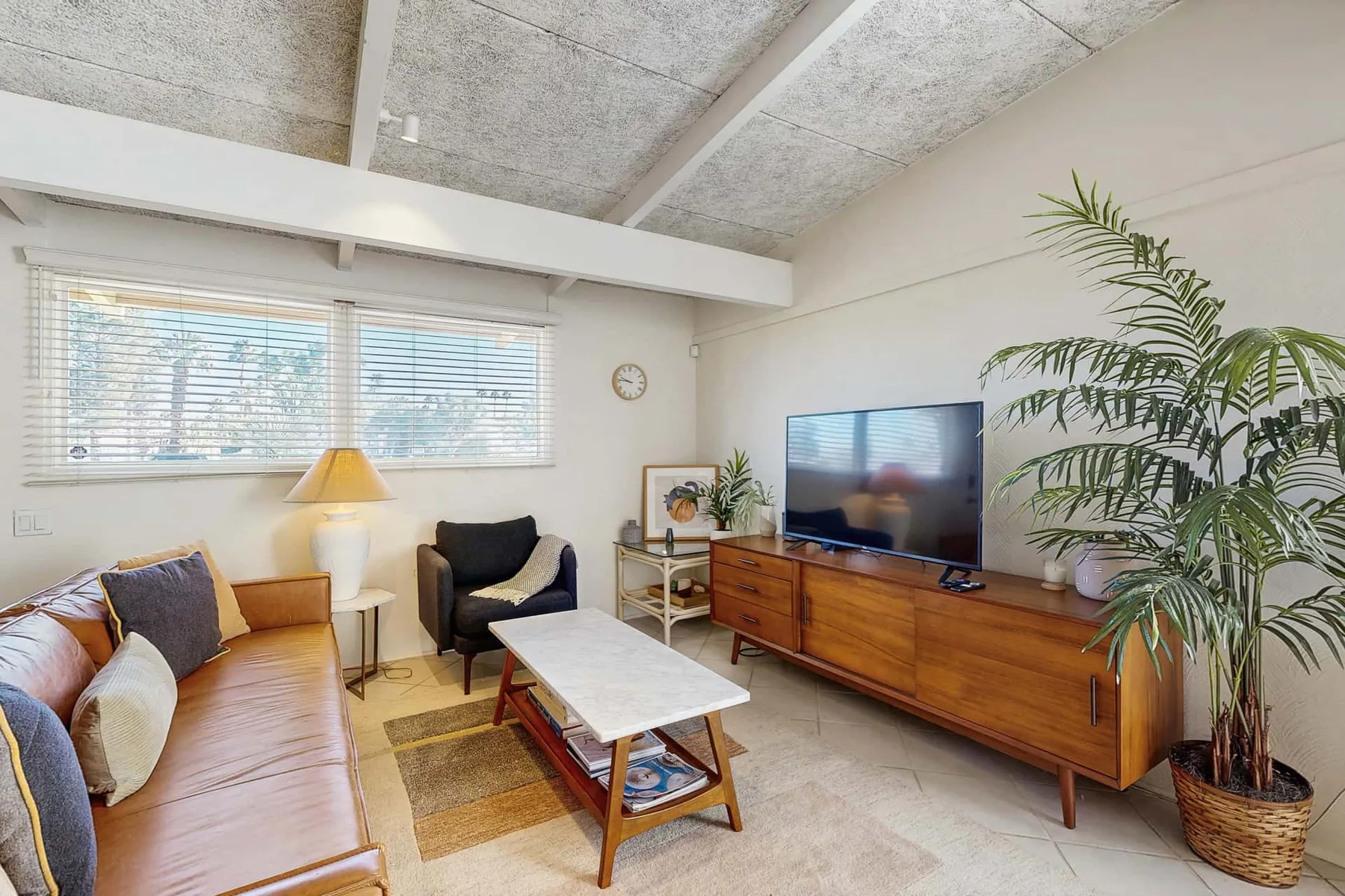 Living room with seating, a coffee table, and a television.