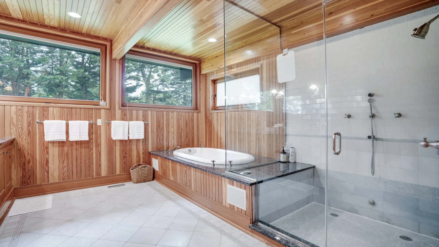 A bathroom with a bathtub and glass-enclosed shower.