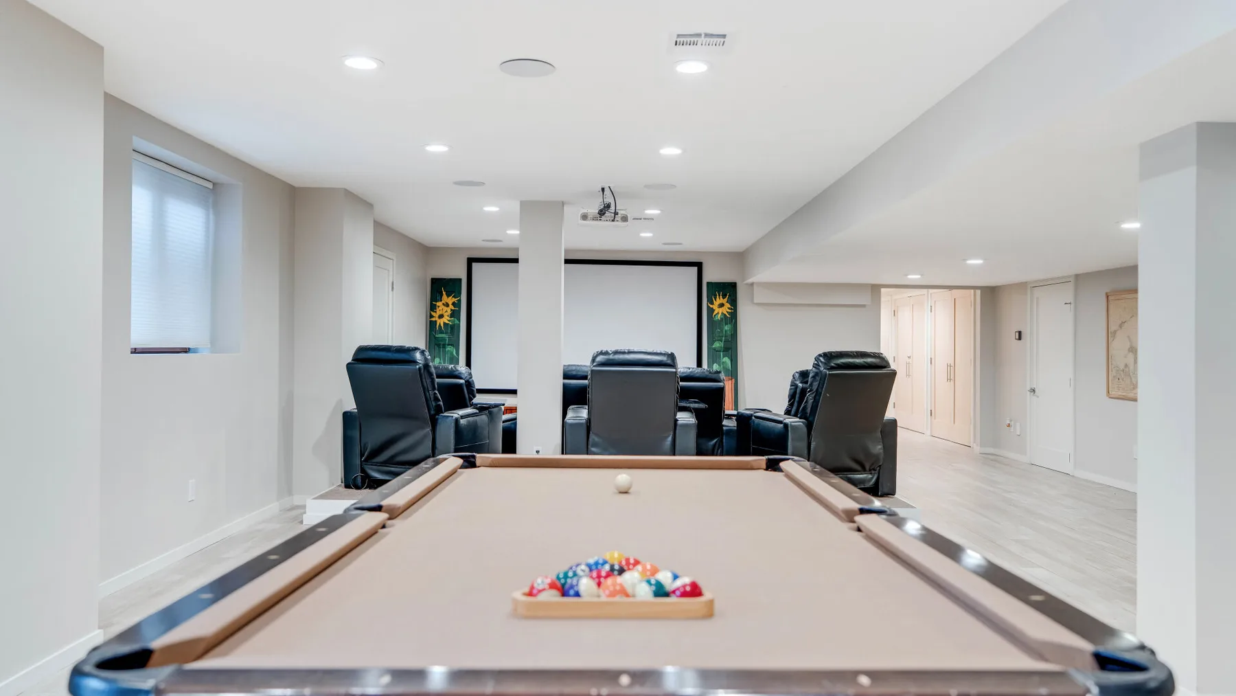 A billiards room with a pool table and seating.