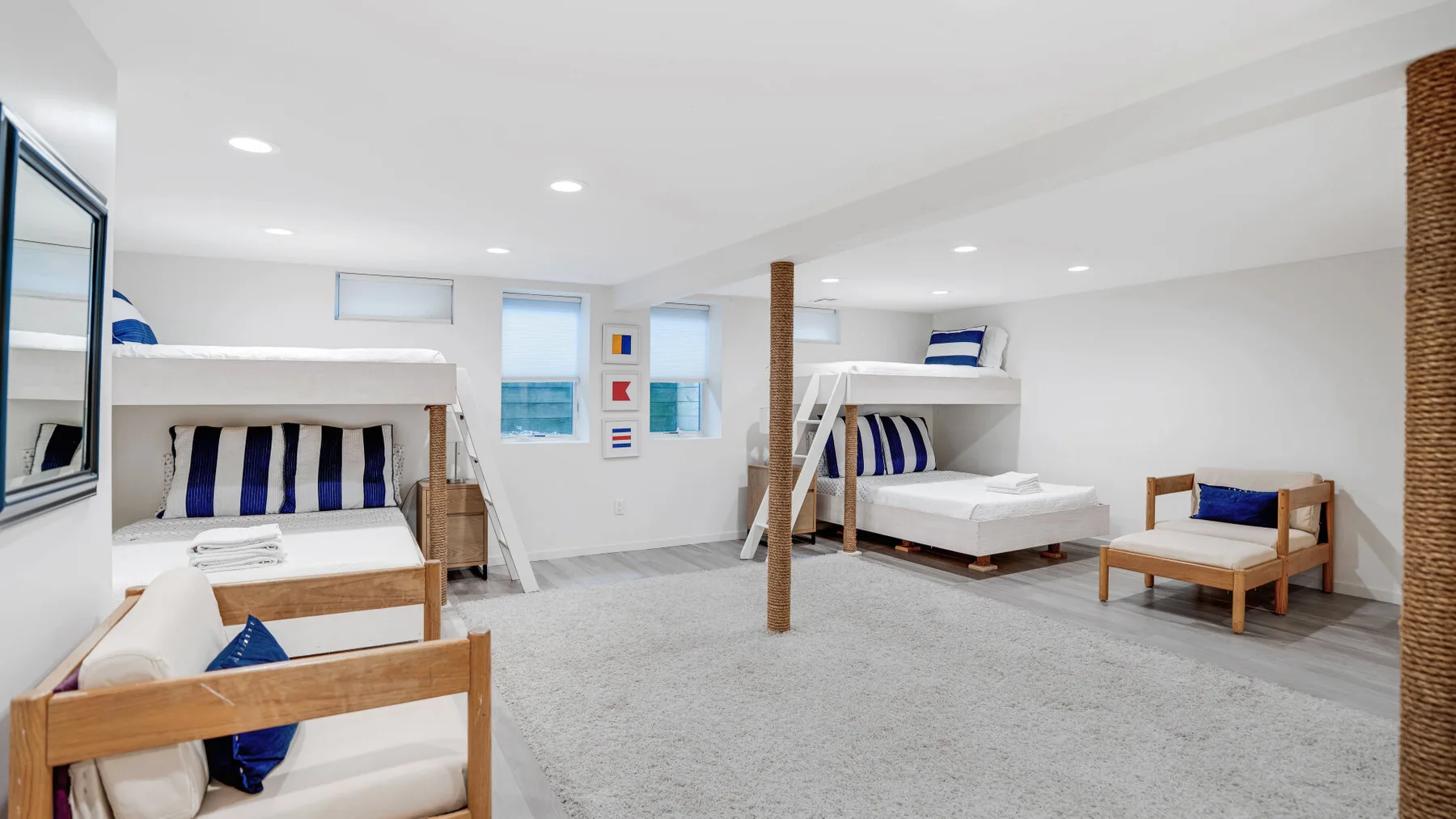 A bright bedroom with several beds and a seating area.