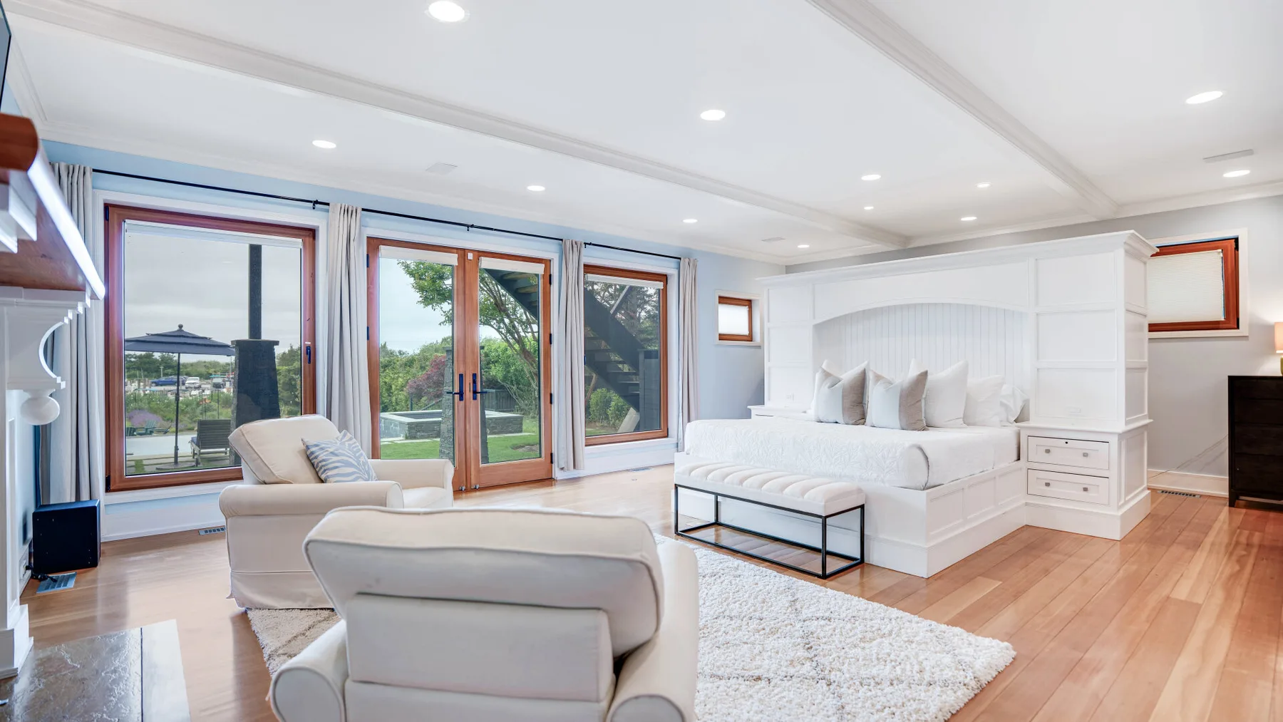 A bright living room with seating beside large windows and glass doors.