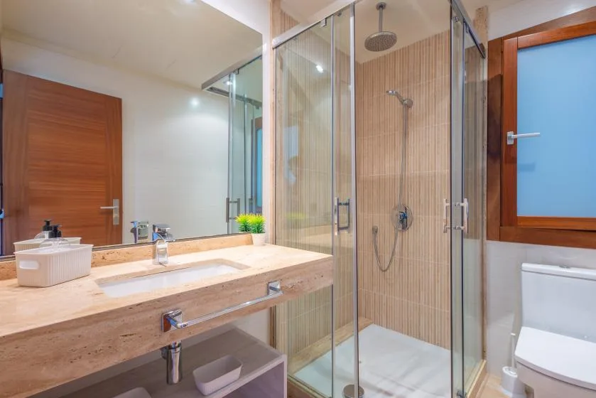 Un baño con un tocador amplio y una ducha con mampara de vidrio.