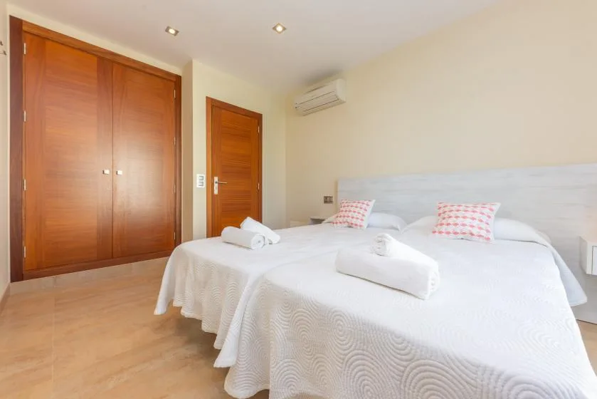 Un dormitorio con una cama grande vestida de blanco y puertas de madera.