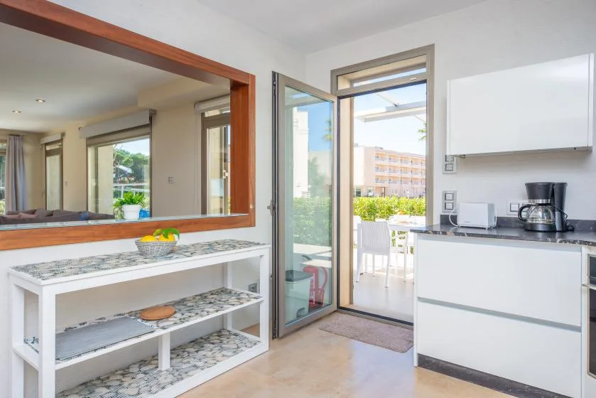 Una cocina luminosa se abre a través de puertas de cristal a un comedor exterior.