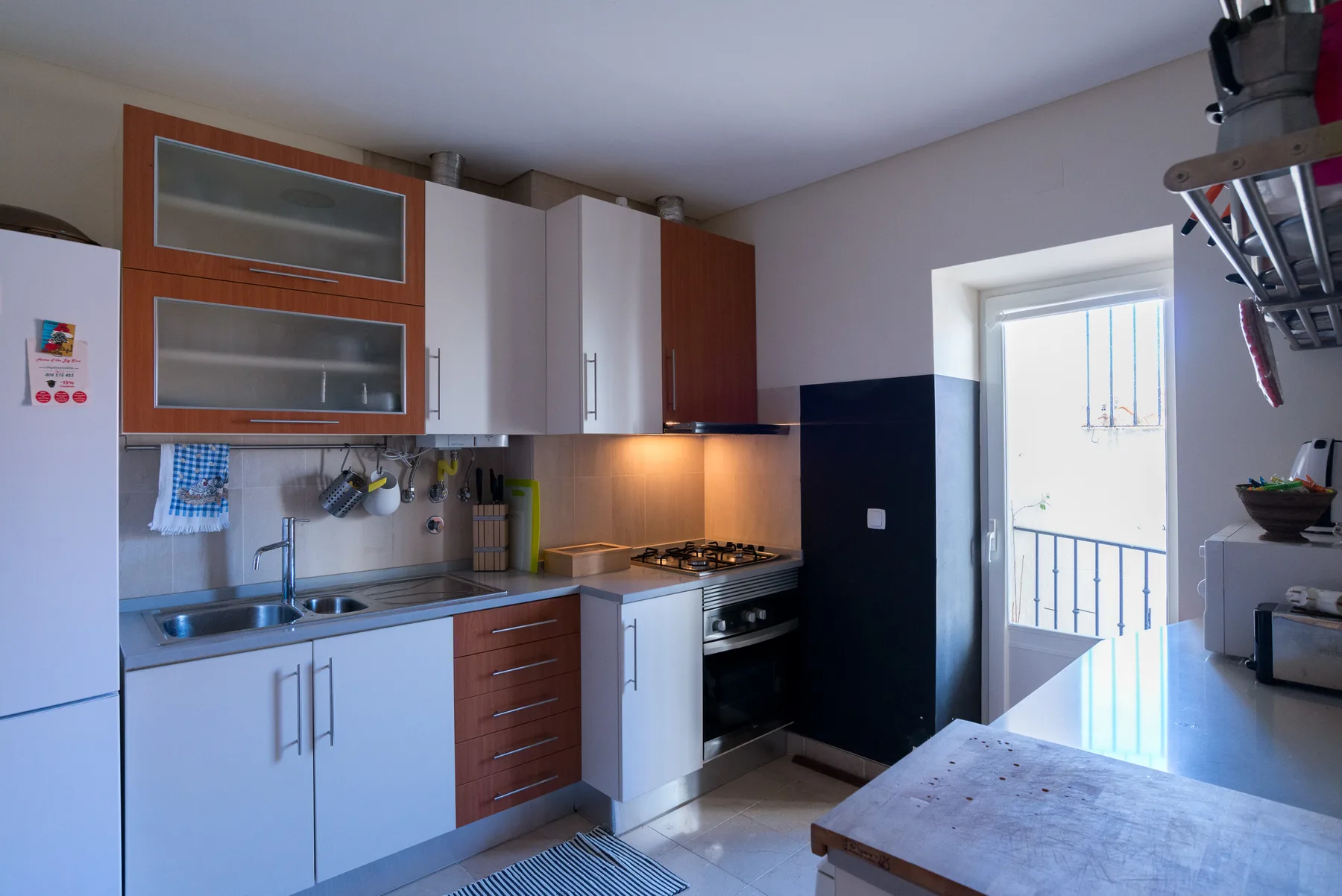Una cocina luminosa con armarios, una encimera y una cocina.