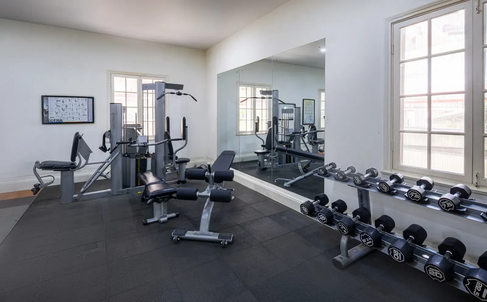 Fitness centre with exercise equipment and free weights.