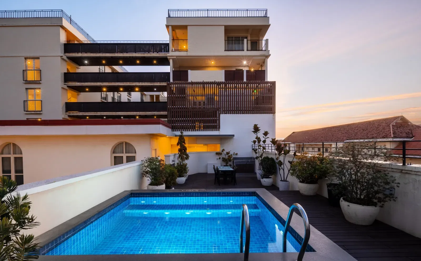 Rooftop swimming pool with lounge seating and city views.