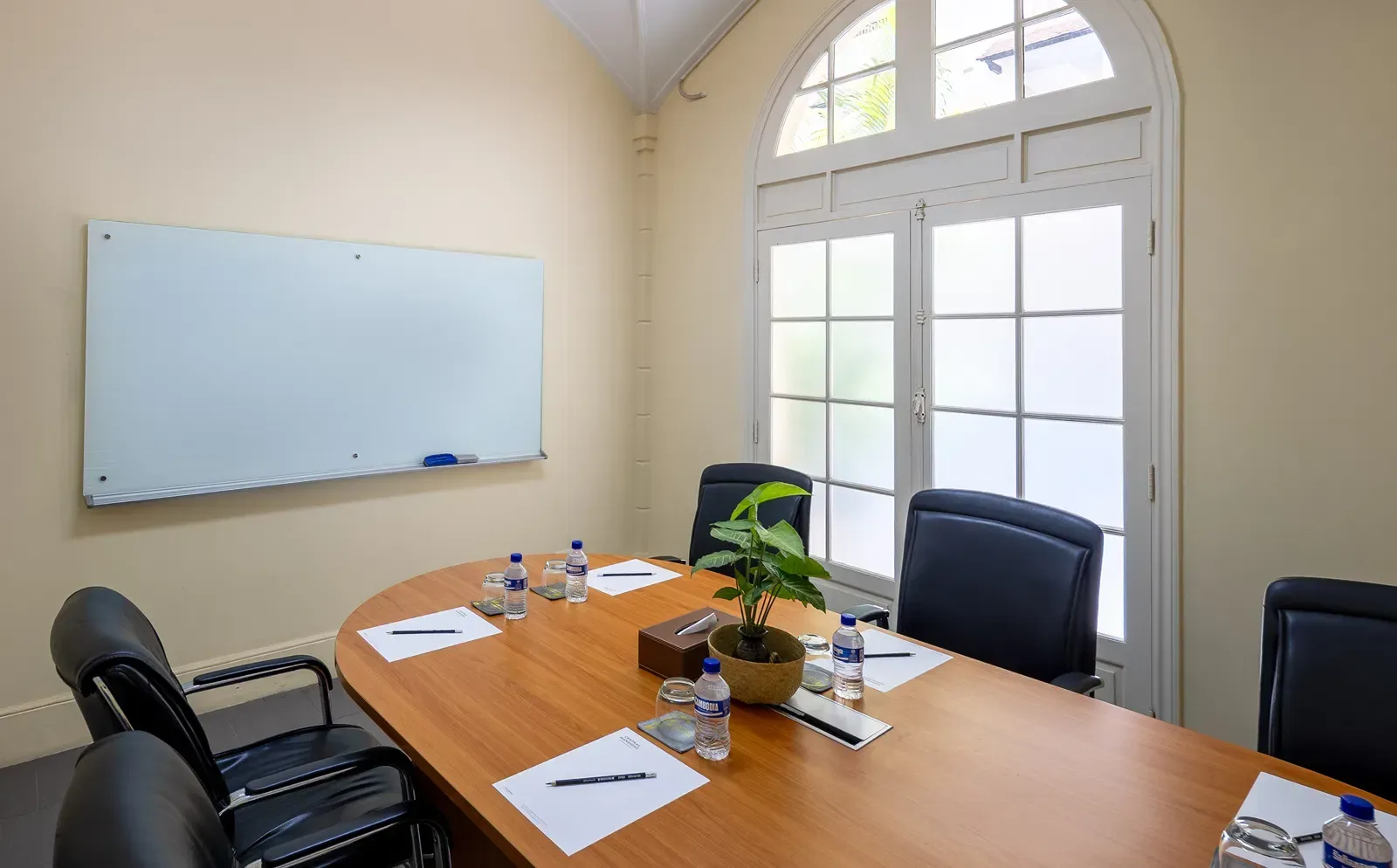 Meeting room with conference table and wall-mounted display.