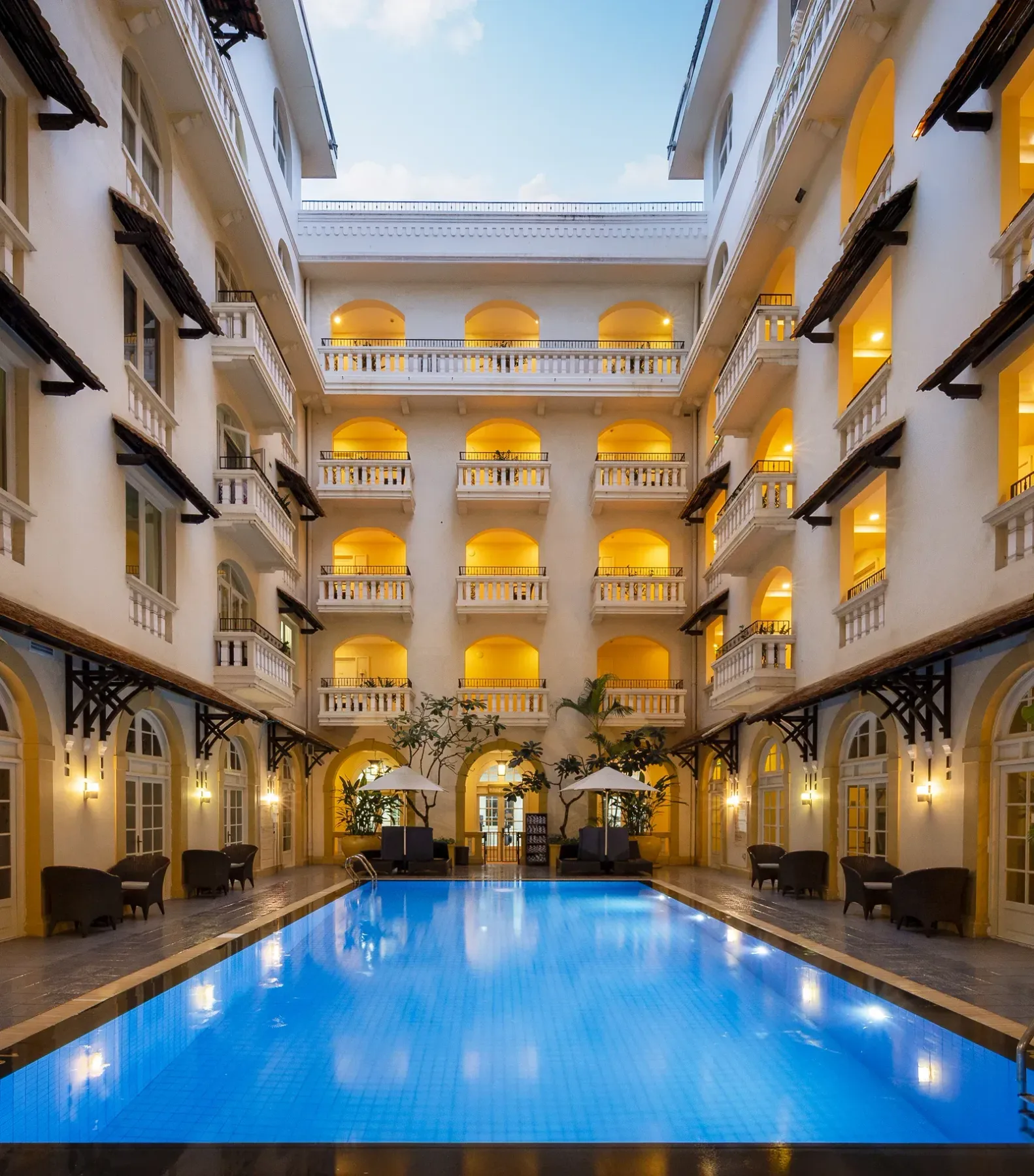 Outdoor swimming pool beside the hotel buildings.