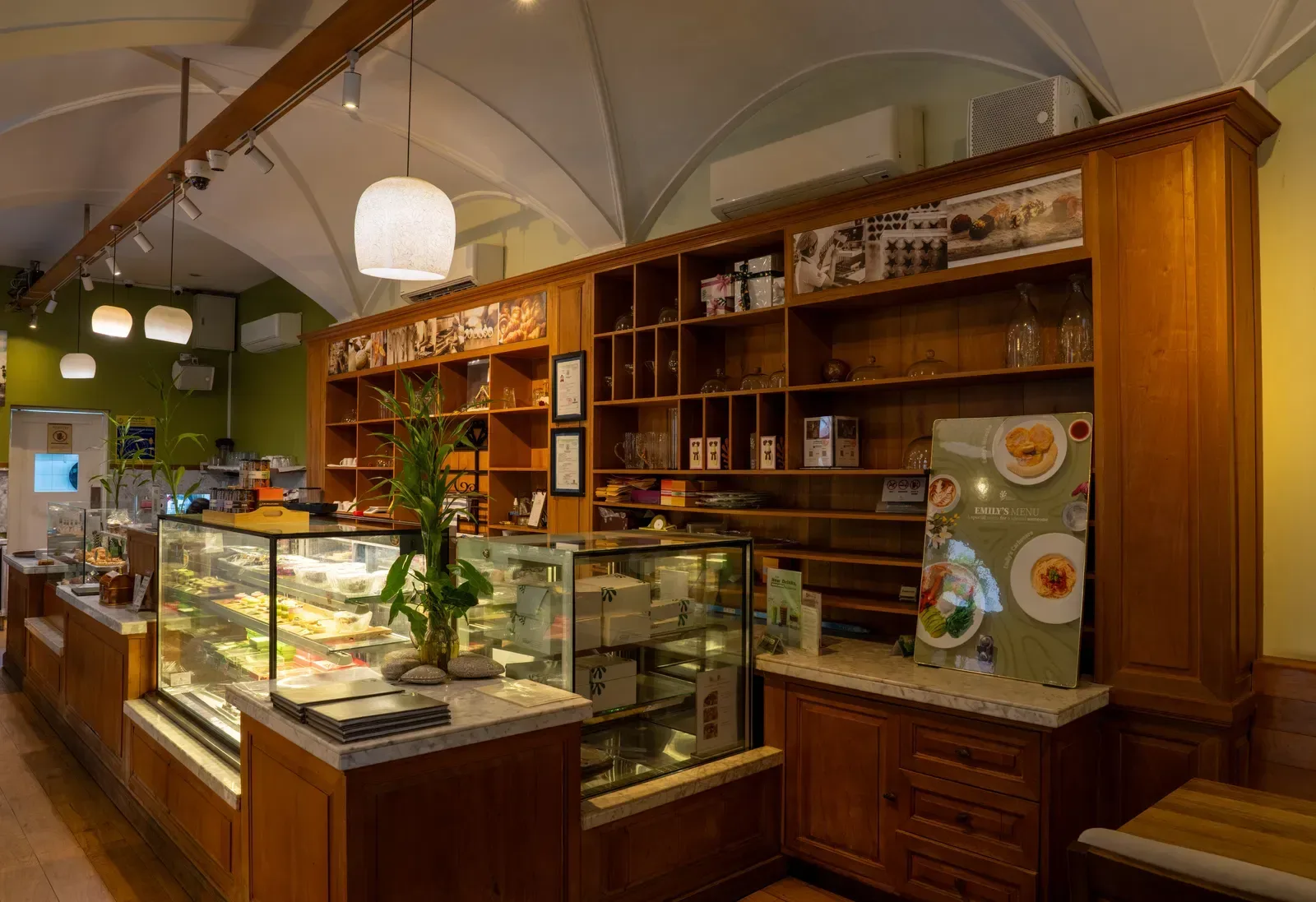 Shop counter with wooden shelving and food displays.