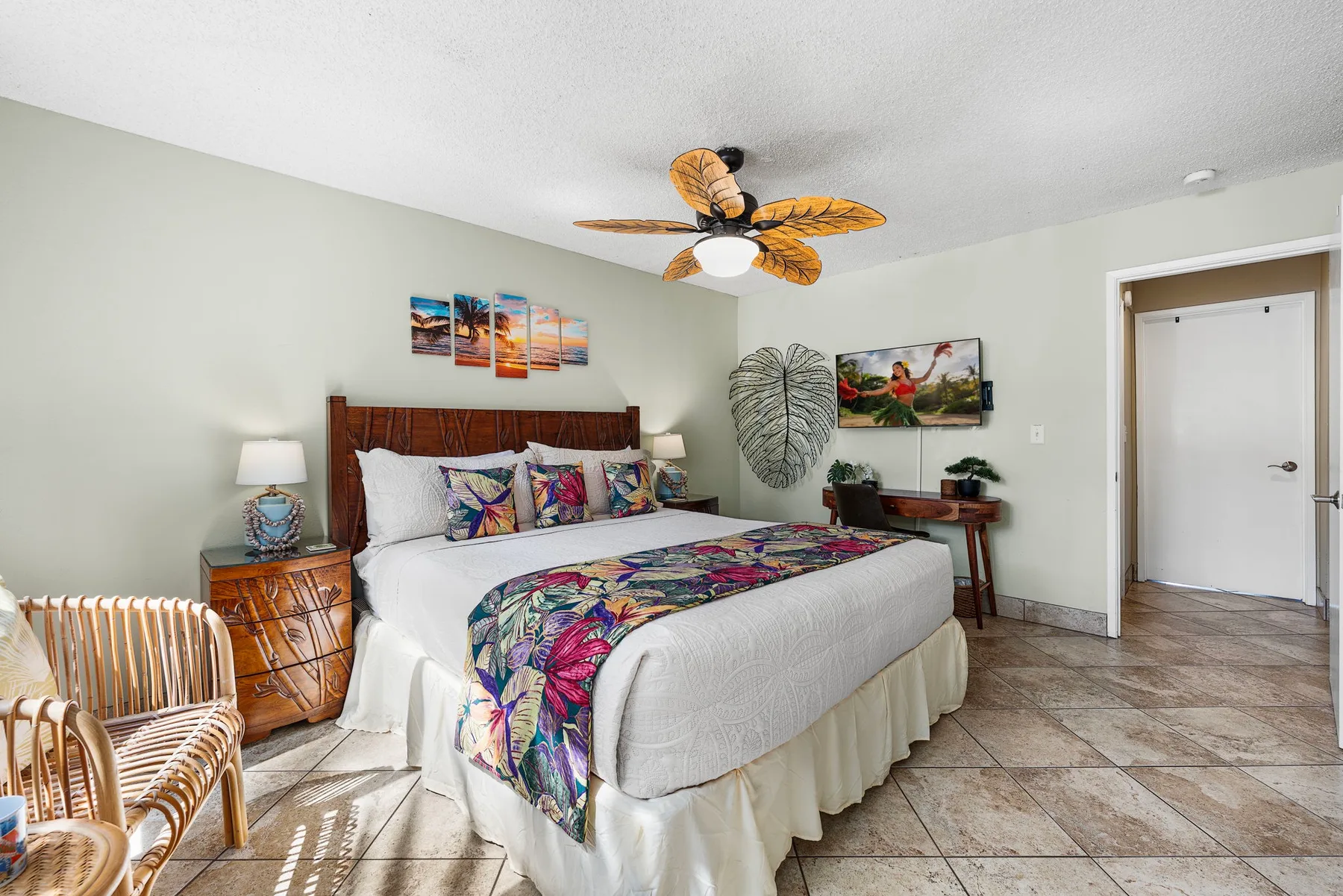 Un dormitorio con una cama vestida con ropa de cama estampada y colorida.