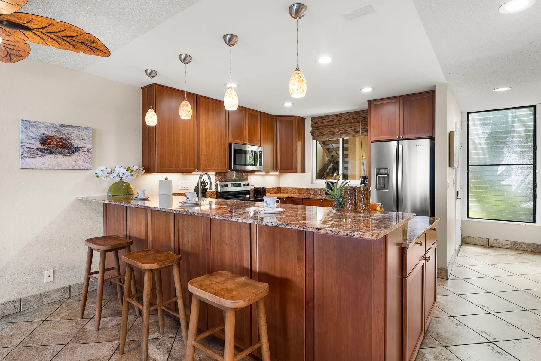Una cocina con una isla grande y lámparas colgantes.