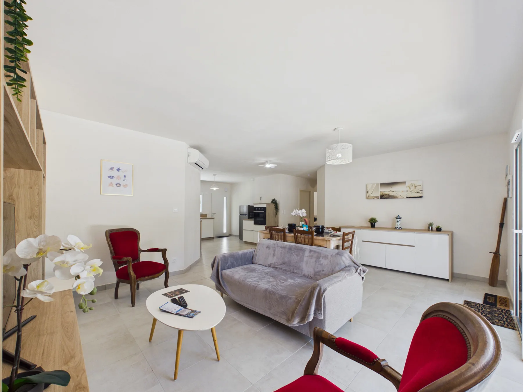 A bright living room with seating, a coffee table, and a dining area.