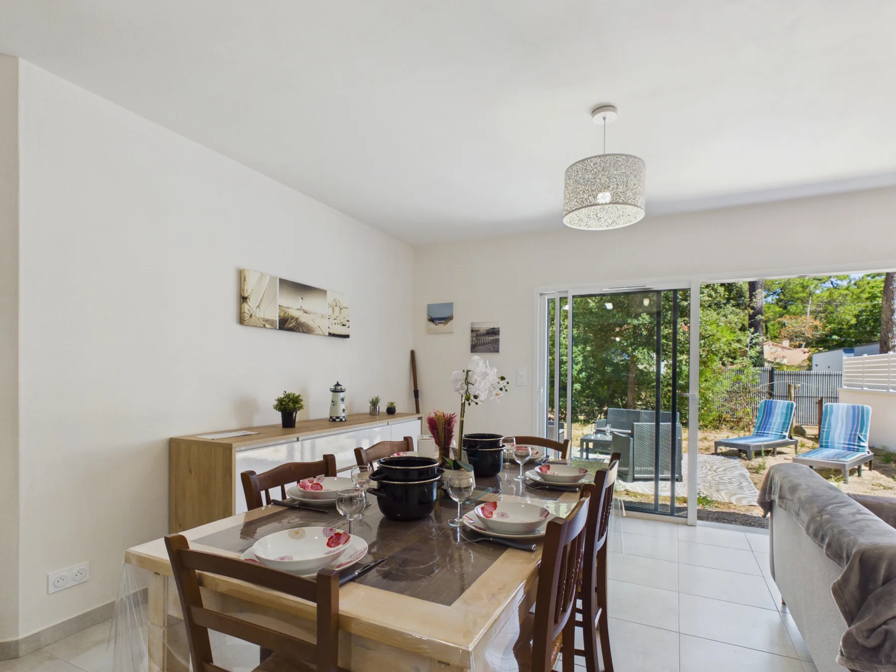 A dining area opens onto a patio through large sliding glass doors.