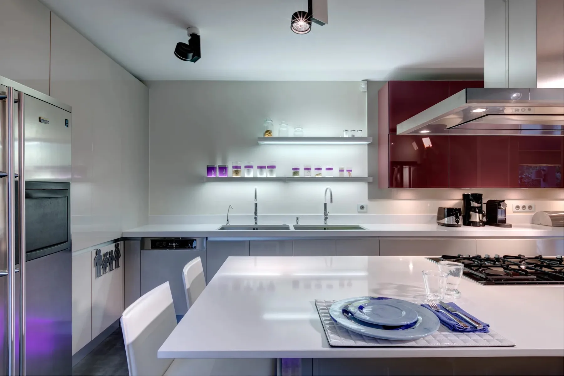 Una cocina moderna con una isla blanca y electrodomésticos de acero inoxidable.