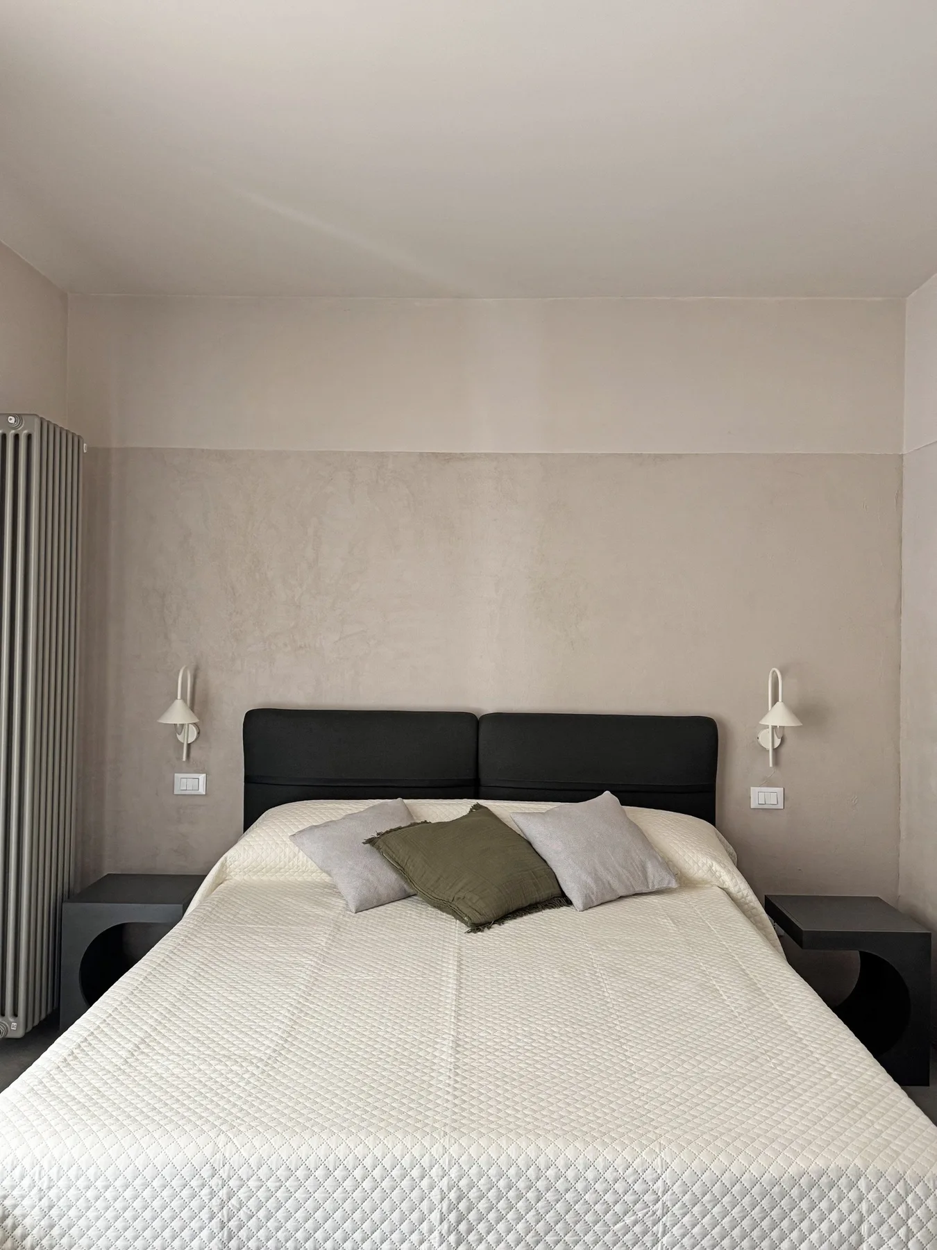 Un dormitorio con una cama vestida con ropa de cama blanca y almohadas.