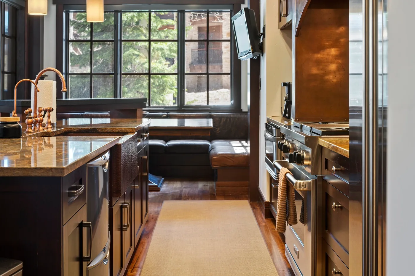 A kitchen with a central island and a window-side seating nook.