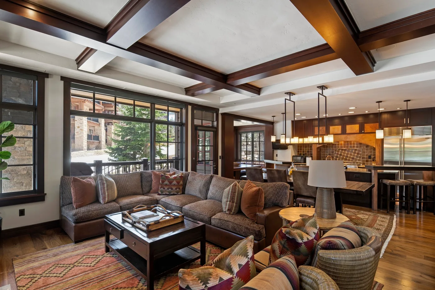 A spacious living room with seating, a coffee table, and an open kitchen.