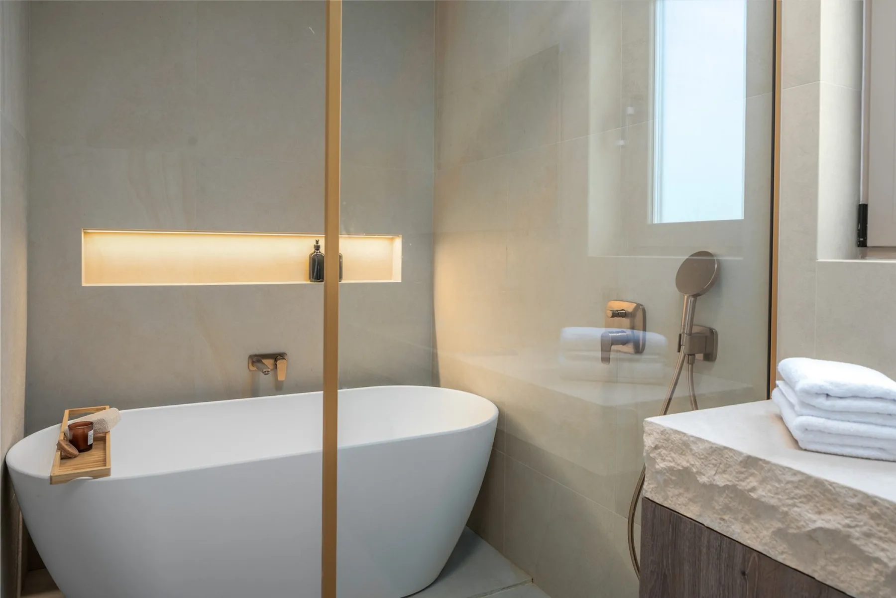 An en-suite bathroom with a bathtub, a shower, a sink, and a toilet