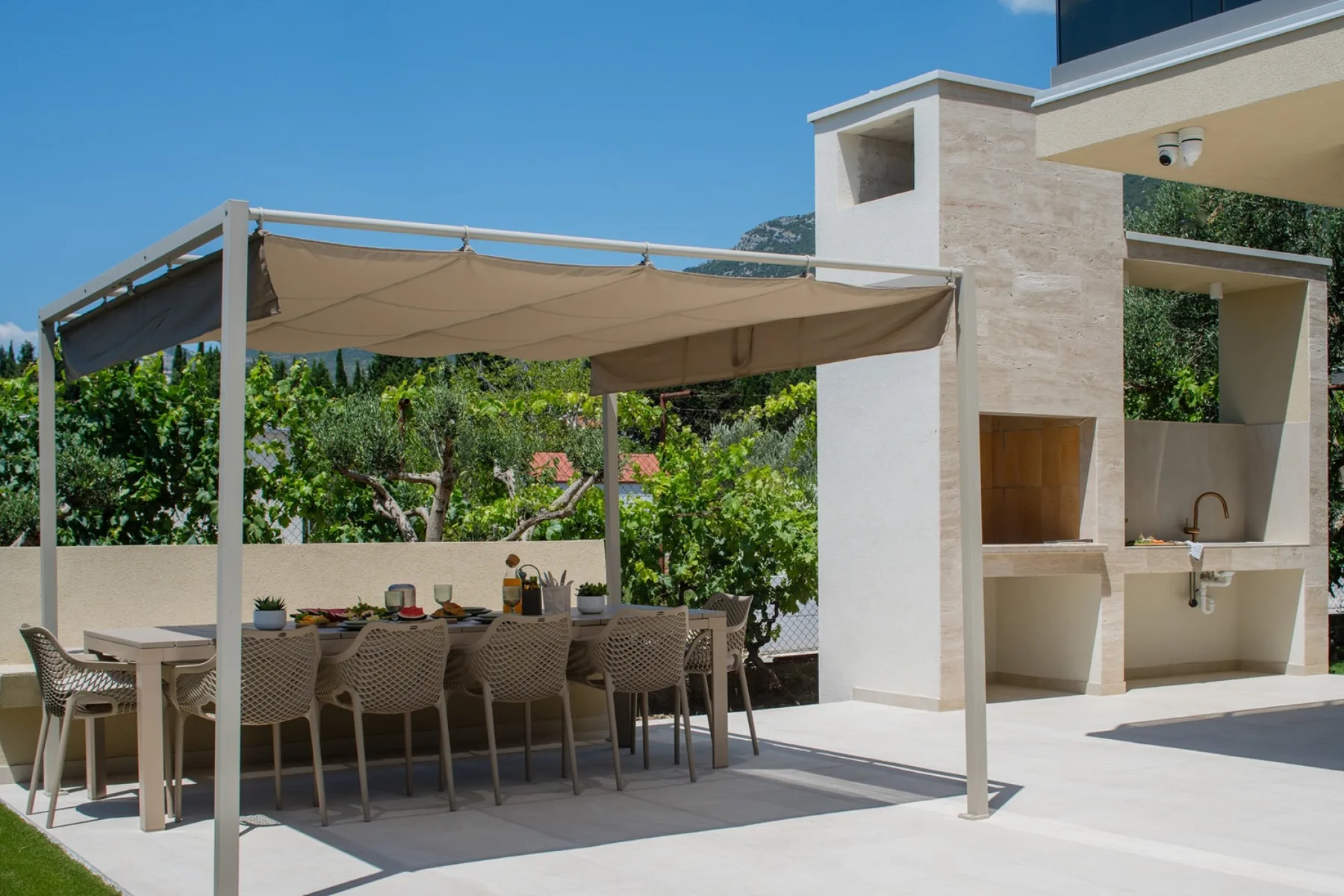 La terraza de comedor a la sombra, con barbacoa de gas y de leña/carbón, está perfectamente situada para disfrutar de comidas al aire libre sin esfuerzo