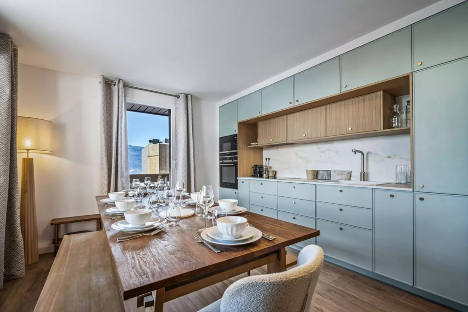 A dining area with a set table beside a modern kitchen.