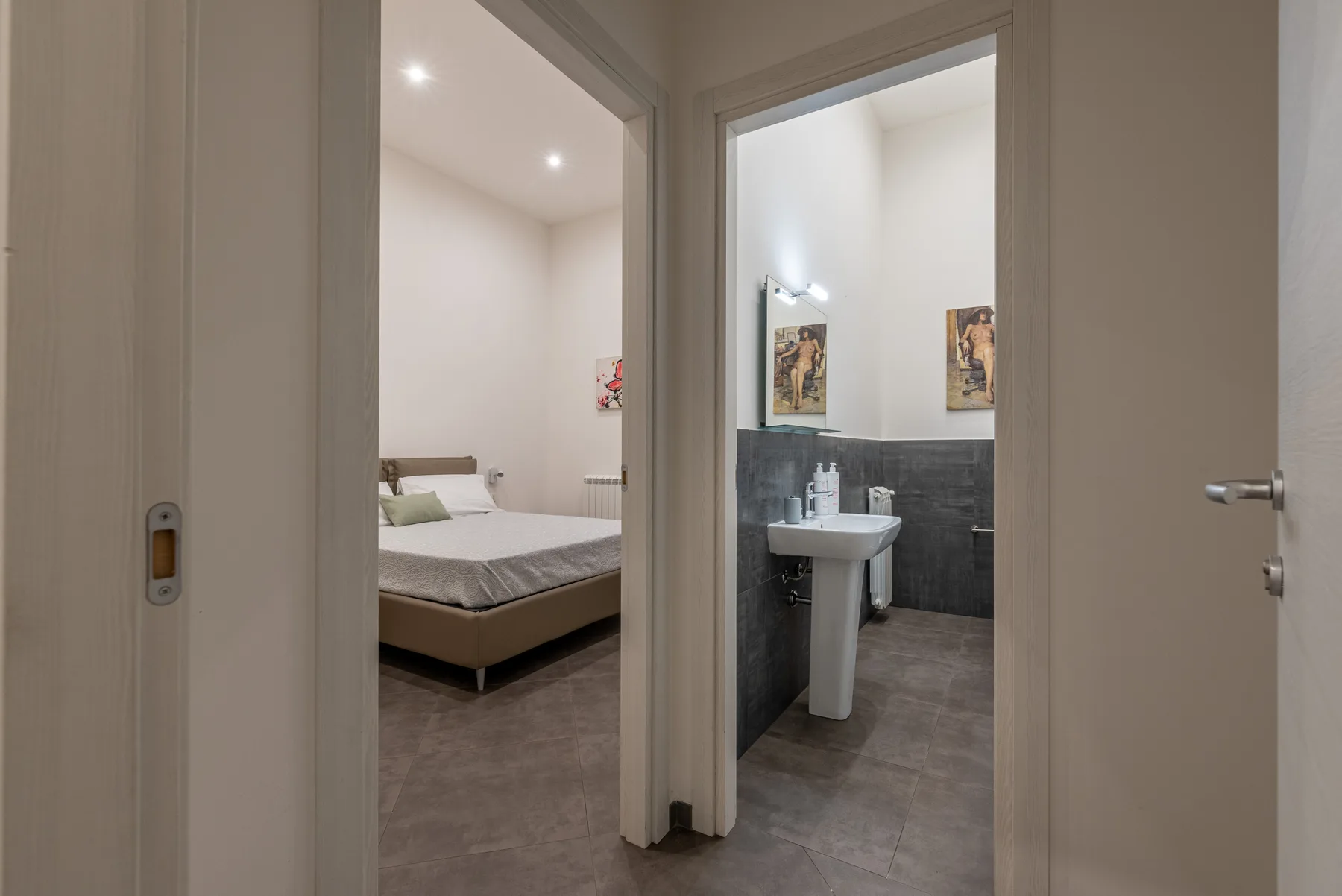 A bedroom and bathroom are visible through two open doorways.