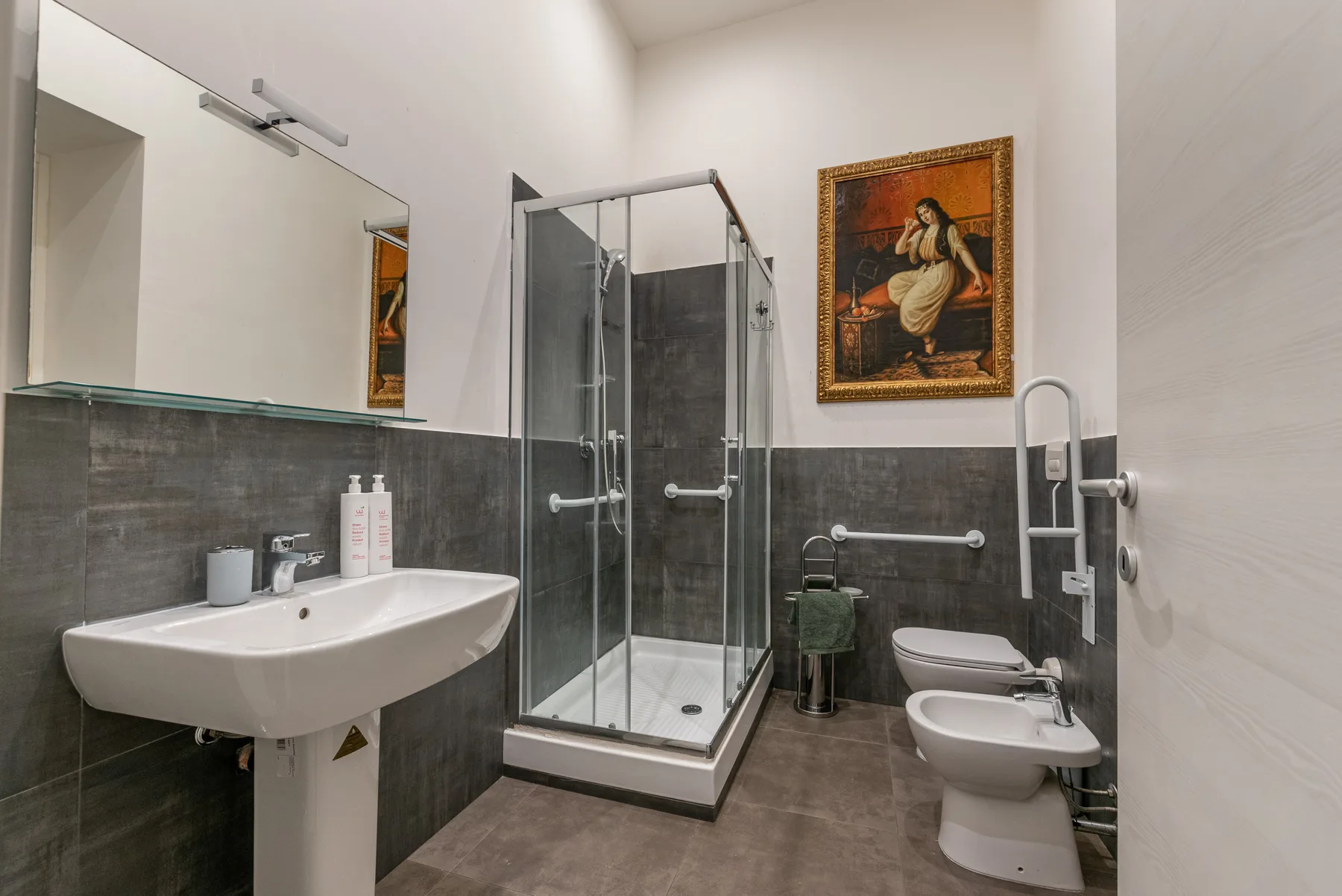 A bathroom with a glass shower, sink, and toilet.