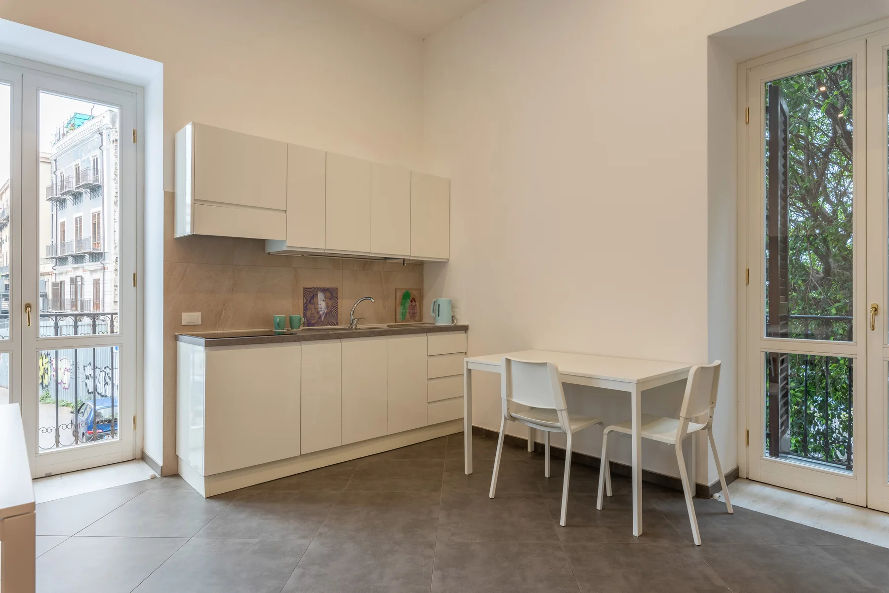 A bright dining area with a table beside a compact kitchen.